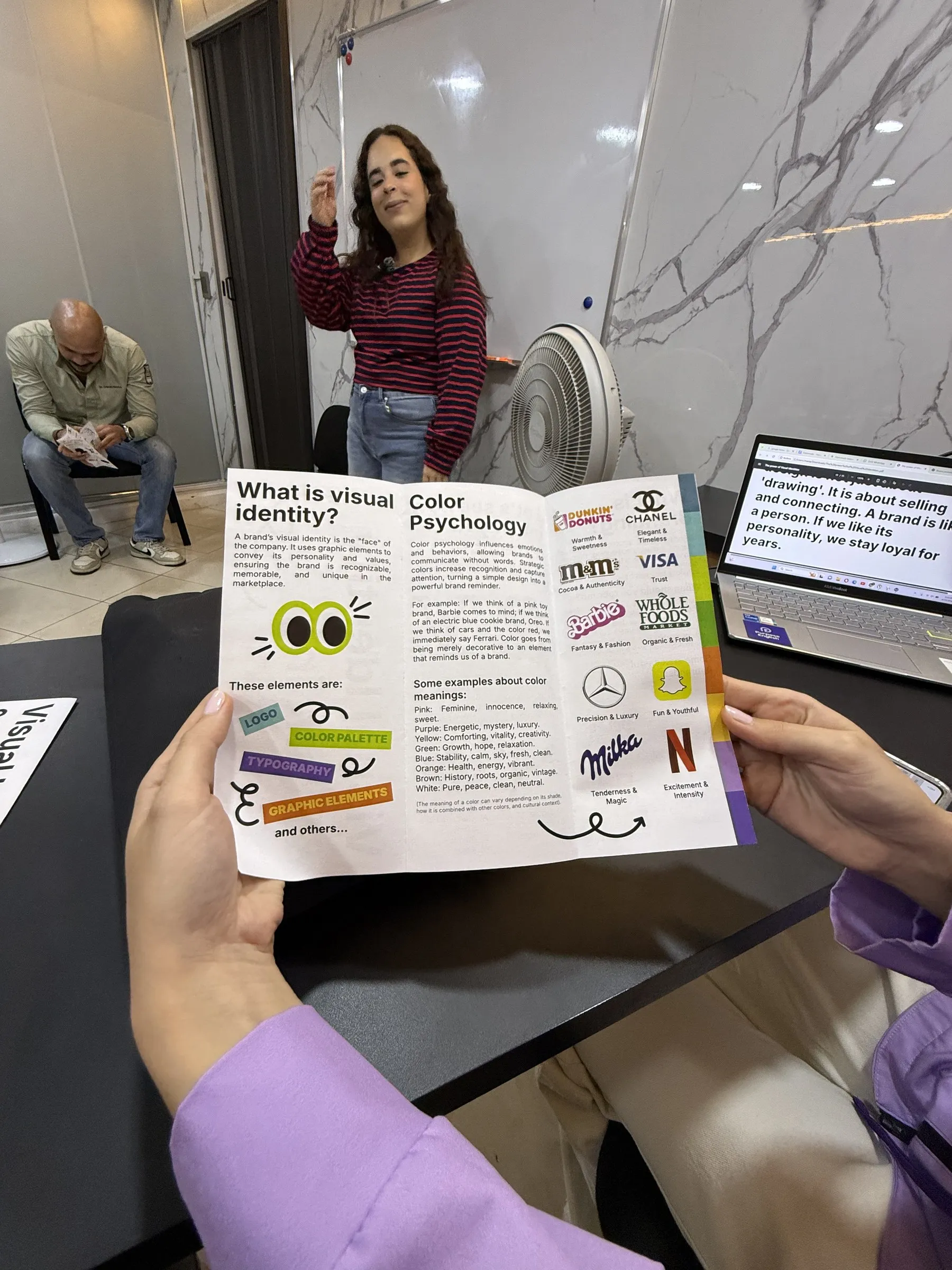 Un estudiante sostiene su proyecto del Purpose Term Project sobre identidad visual y branding