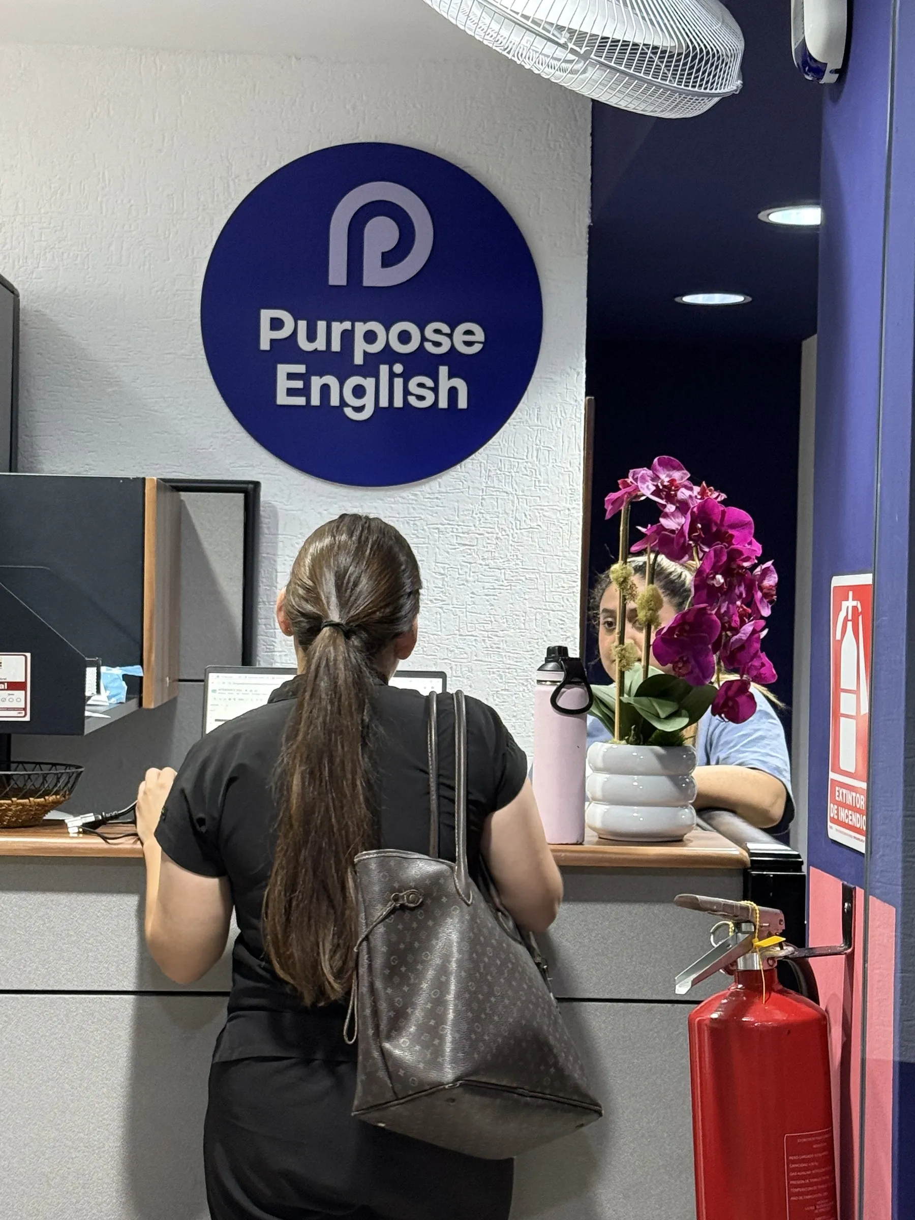 Recepción de Purpose English, con el logo del instituto en la pared